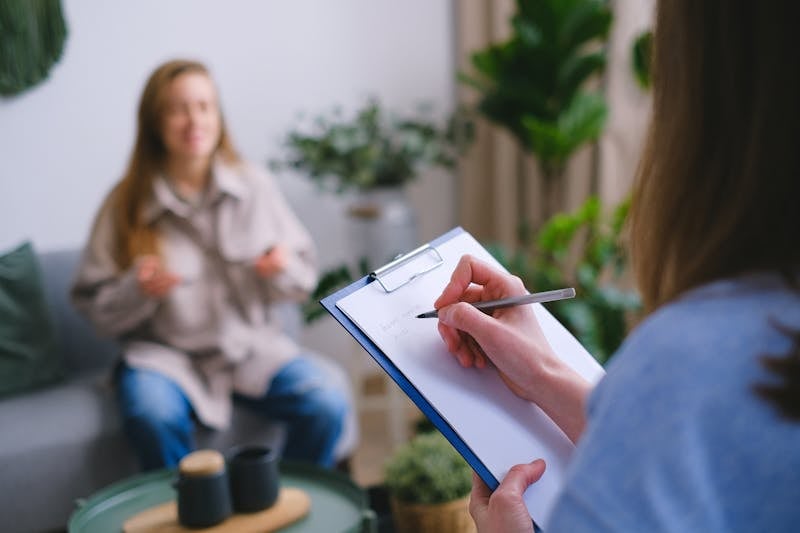 Therapeutin notiert während einer einfühlsamen Therapiesitzung in der Wortwelt Logopädie
